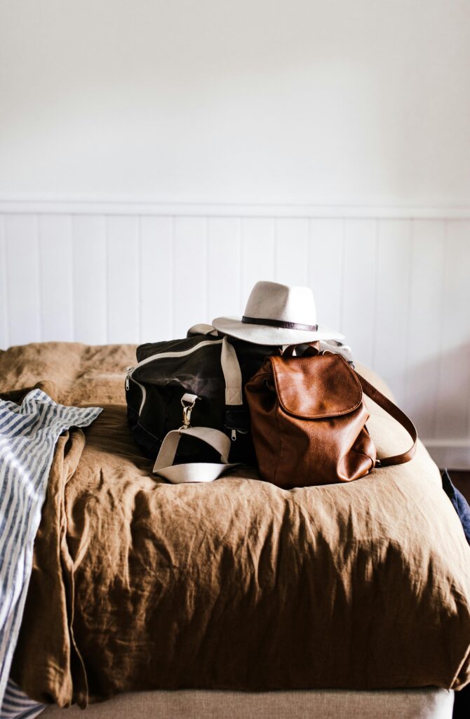 travel bag and hat on bed