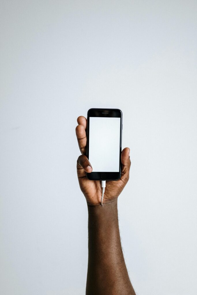 android phone in hand with charging cable