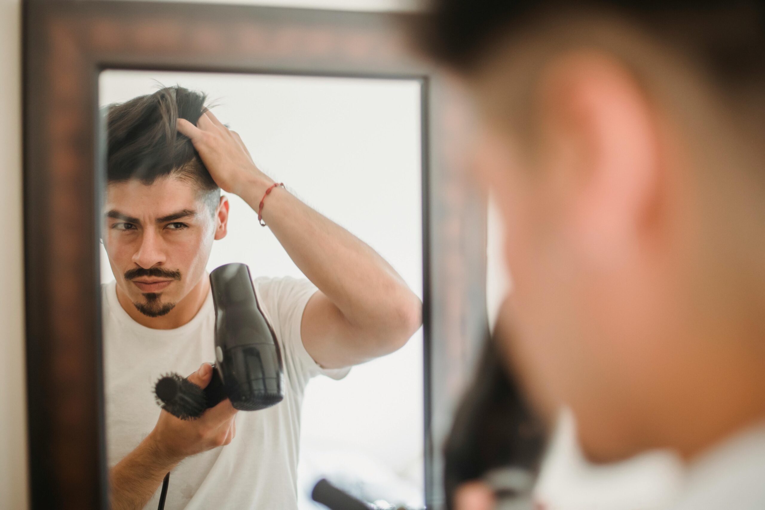 man blow drying hair